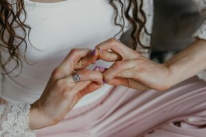 Händer med lila nagellack som visar upp en manikyr.